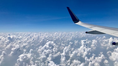 Airplane wing over cloudy sky - Free virtual background to download